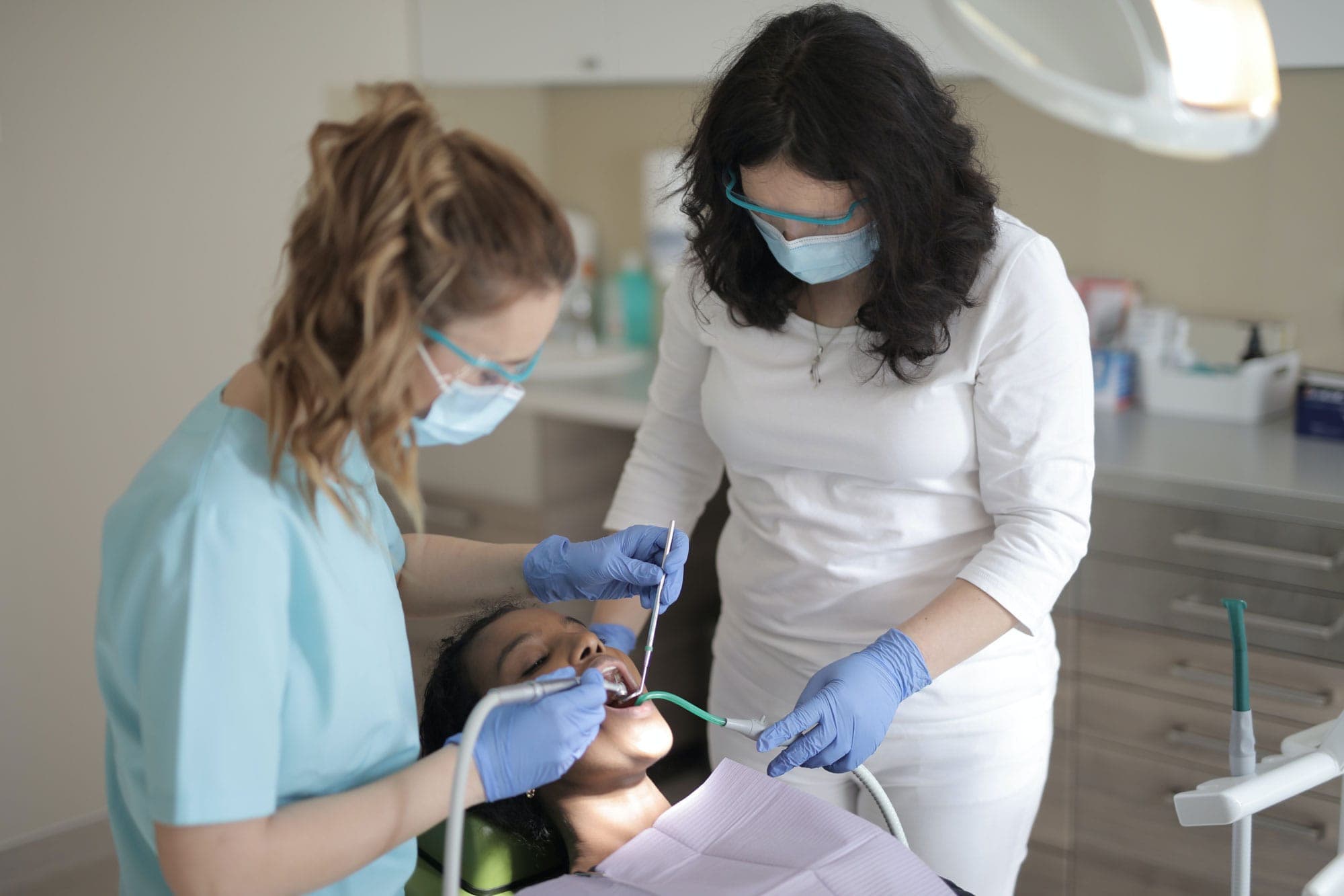 Two clinicians treating a patient together in a dental surgery